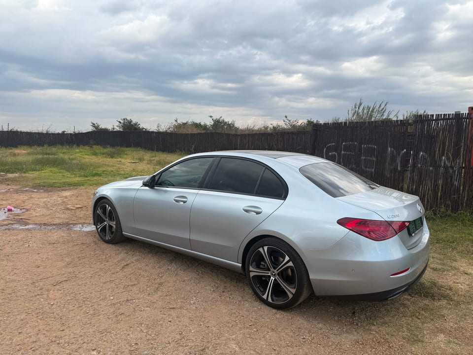 Rear three-quarter view of the car under a heavy overcast sky